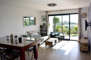 a living room with a couch and a table at Charmant 2P de 45m2 au calme, Vue Mer Panoramique, Terrasse Privée 30m2, Piscine in Saint-Laurent-du-Var