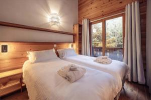 a bedroom with two beds with towels on them at Madame Vacances Chalet Morgane in La Tania