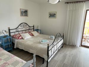 a bedroom with a large bed and a window at Apartments Nediljka in Grebaštica