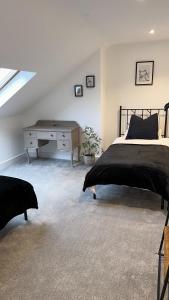 a bedroom with a bed and a desk at Modern Harrogate house sleeps 10, cinema room & hot tub in Harrogate