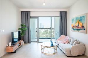 een woonkamer met een bank en een tv bij Downtown Views 2BR Luxury Apartment Pool and City Skyline in Dubai