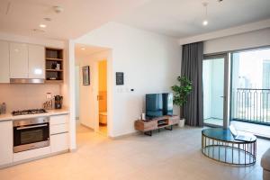 een woonkamer met een keuken en een televisie bij Downtown Views 2BR Luxury Apartment Pool and City Skyline in Dubai