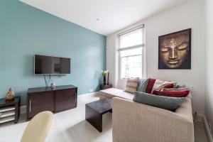 uma sala de estar com um sofá e uma televisão em Charming 1 BR flat near Hyde Park em Londres