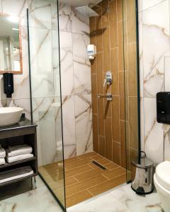 a shower with a glass door in a bathroom at Grand 464 Otel in Rize