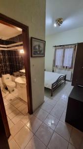 um quarto com um quarto com uma cama e uma casa de banho em Obrava Guesthouse Kotroni Trikalon em Kotrónion