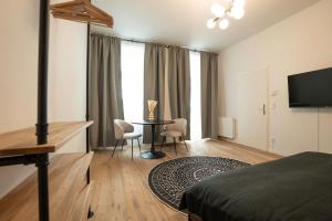 a bedroom with a table and chairs and a television at Modern apartment with a balcony near Belvedere in Vienna