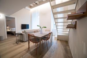ein Esszimmer und ein Wohnzimmer mit Tisch und Stühlen in der Unterkunft Be Mate Torino Centro in Turin