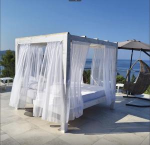 a canopy bed on a patio with an umbrella at Green Pino Seaview Studios in Bar