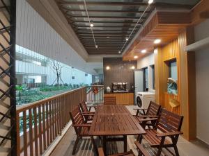 cafetería con mesa de madera y sillas en el balcón en CĂN HỘ CAO CẤP CÓ HỒ BƠI TẠI BIÊN HÒA, en Bien Hoa