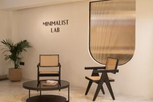 a mirror and two chairs and a table in a room at Minimalist Poshtel & Suites in New Delhi