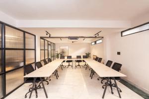 a long conference room with tables and chairs at Minimalist Poshtel & Suites in New Delhi