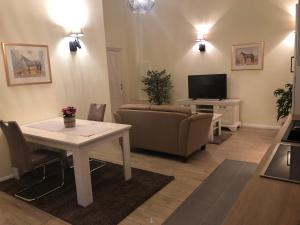 a living room with a couch and a table and a television at Ferienapartments Reitanlage Schenksolz in Schenklengsfeld