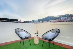 Duas cadeiras e uma mesa numa varanda com uma garrafa de vinho em Luderna - Arc de Sant Marti Barcelona em Barcelona