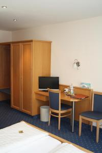 a room with a desk with a computer and chairs at Hotel-Gasthof zur Krone in Riedenburg