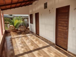 een lege veranda met een houten deur en stoelen bij CHACÁRA SOL NASCENTE in Lavras da Mangabeira