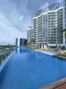 a large swimming pool in front of a large building at Mactan Newtown Beach Condo by FJCIVO in Lapu Lapu City