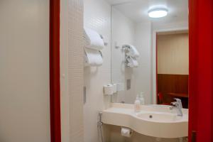 a bathroom with a sink and a mirror at Omena Hotel Helsinki City Centre in Helsinki