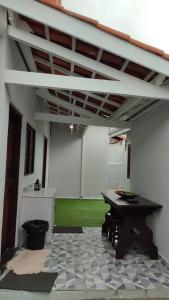 Habitación blanca con mesa y suelo verde en excelente casa ótima localização en Ubatuba