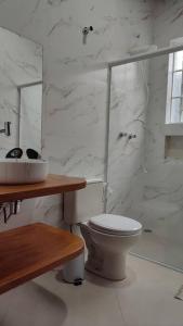 a white bathroom with a toilet and a shower at excelente casa ótima localização in Ubatuba