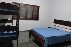 excelente casa ótima localização في أوباتوبا: غرفة نوم مع سرير بطابقين وسرير أزرق