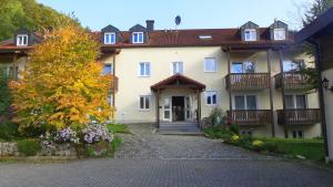 a large white house with a driveway in front of it at Hotel-Gasthof zur Krone in Riedenburg