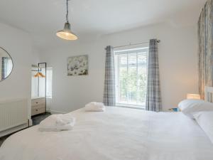 a large white bed in a bedroom with a window at 2 Bed in Blaenau Ffestiniog 79144 in Blaenau-Ffestiniog