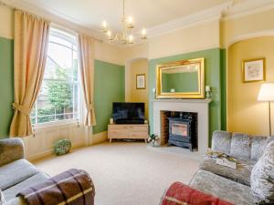 a living room with a fireplace and a television at 4 Bed in Darley Dale 79020 in Great Rowsley