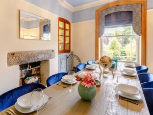 a dining room with a wooden table and a fireplace at 4 Bed in Darley Dale 79020 in Great Rowsley