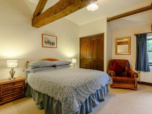 una camera con letto e sedia di 5 Bed in Brecon BN038 a Llanspyddid