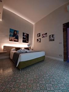 um quarto com uma cama e quadros na parede em Domus Duomo B&B Napoli em Nápoles