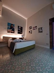 a bedroom with a bed and pictures on the wall at Domus Duomo B&B Napoli in Naples