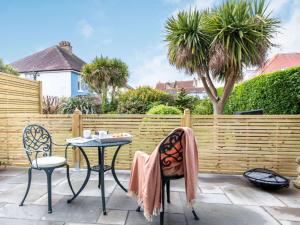 un patio con 2 mesas y sillas y una valla en 1 Bed in Paignton 87811 en Paignton
