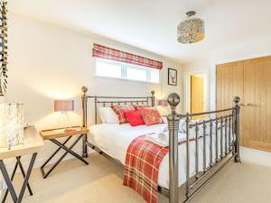 a bedroom with a bed with red pillows on it at 1 Bed in Sherborne 87916 in Bradford Abbas