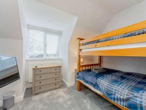 a bedroom with a bunk bed and a dresser at 4 Bed in Penygroes 86423 in Pen-y-groes