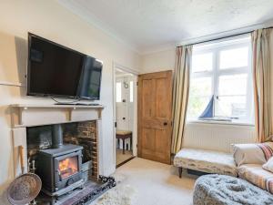 a living room with a fireplace with a flat screen tv at 5 bed in Syderstone KT180 in Syderstone