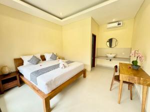 a bedroom with a bed and a table and a sink at Dega Gardens in Canggu