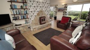 a living room with a couch and a fireplace at Seacliffs in Rhossili