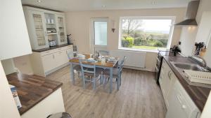 a kitchen with a table and chairs and a window at Seacliffs in Rhossili