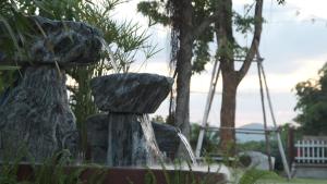a water fountain with two rocks in a park at NaKan Farmstay in Kanchanaburi City