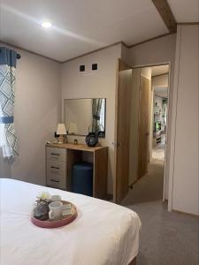 ein Schlafzimmer mit einem Bett und einem Tablett mit Tassen drauf in der Unterkunft The Retreat 16 - pet friendly, WiFi, and a bath - Golden Palm Resort - Meadow Lakes Caravan & Lodge Hire in Chapel Saint Leonards