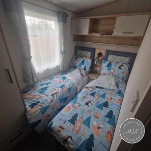 ein kleines Schlafzimmer mit 2 Einzelbetten und einem Bettlaken in der Unterkunft The Retreat 16 - pet friendly, WiFi, and a bath - Golden Palm Resort - Meadow Lakes Caravan & Lodge Hire in Chapel Saint Leonards