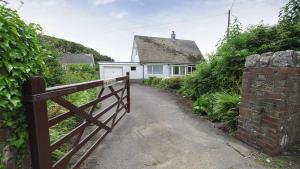 a house with a fence and a driveway at Seacliffs in Rhossili