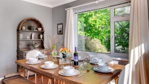 a dining room with a wooden table and a window at Roman Bridge Close in Oystermouth