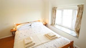 a bedroom with a bed and a window at Middleton Hall Cottage in Rhossili