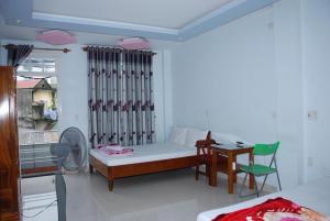 a bedroom with a bed and a table and a chair at Anh Tuấn Motel in Hue