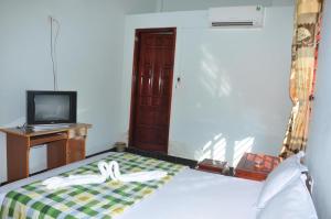 a room with a bed and a tv and a television at Anh Tuấn Motel in Hue