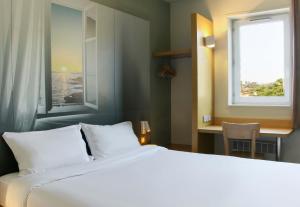 - une chambre avec un lit blanc et une fenêtre dans l'établissement B&B HOTEL Fréjus Roquebrune-sur-Argens, à Roquebrune-sur Argens