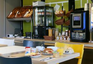 una mesa con comida para el desayuno y bebidas en ella en B&B HOTEL Fréjus Roquebrune-sur-Argens en Roquebrune-sur-Argens