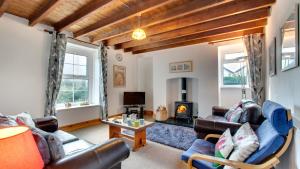a living room with leather furniture and a fireplace at West End Cottage in Llangennith