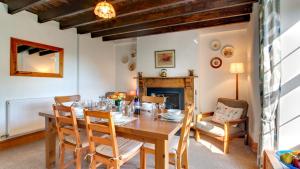 a dining room with a table and chairs and a fireplace at West End Cottage in Llangennith